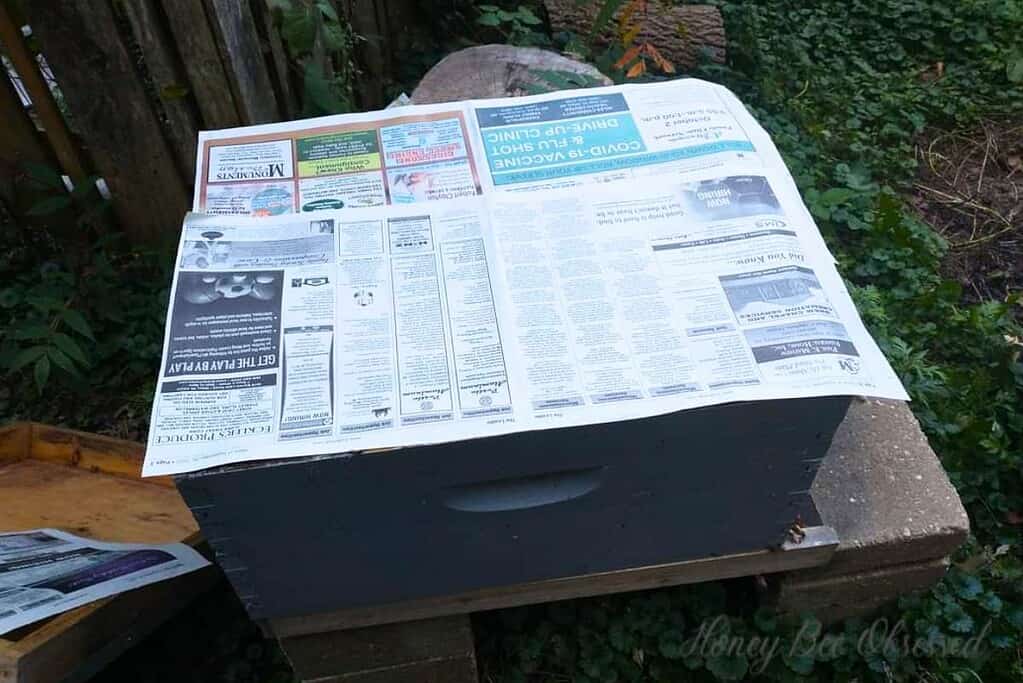 Photo of a newspaper on top of the original hive for a paper combine.